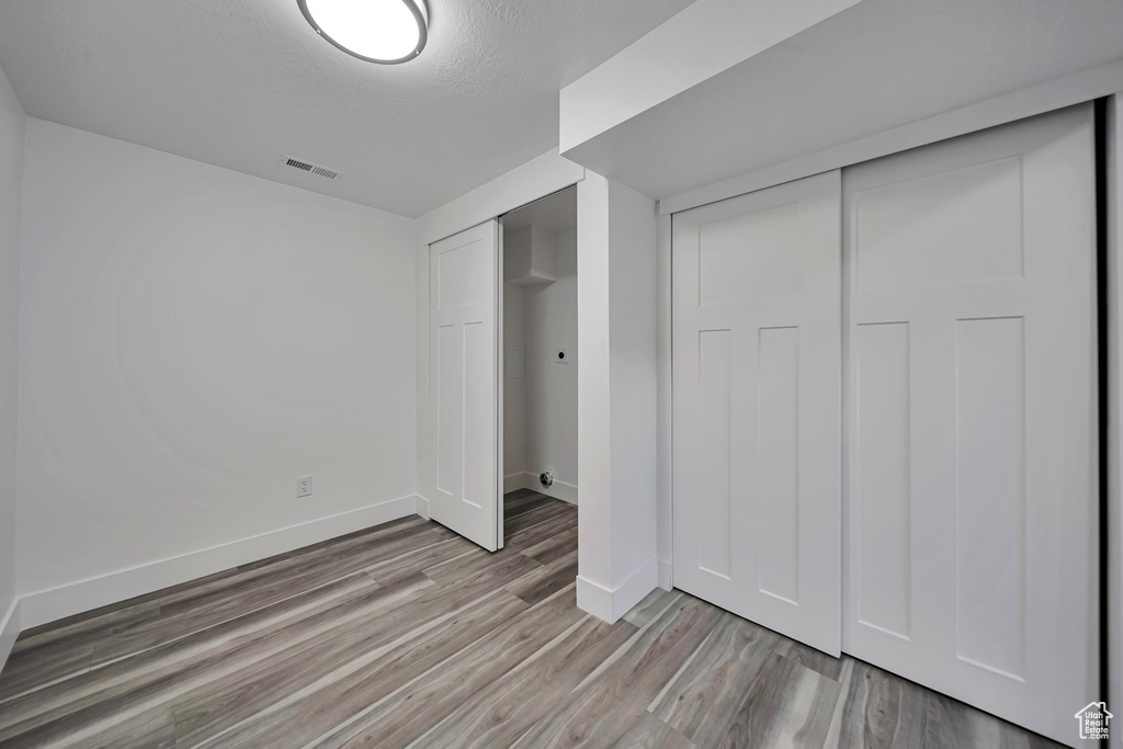 Unfurnished bedroom with light wood-style floors and baseboards