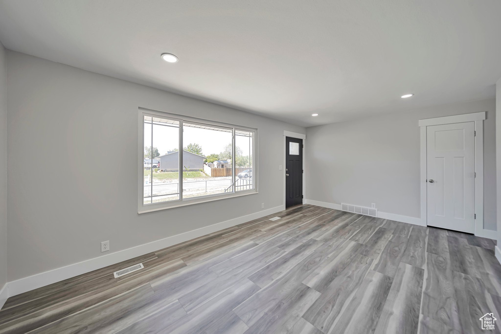 Unfurnished living room with recessed lighting, baseboards, and light wood-type flooring