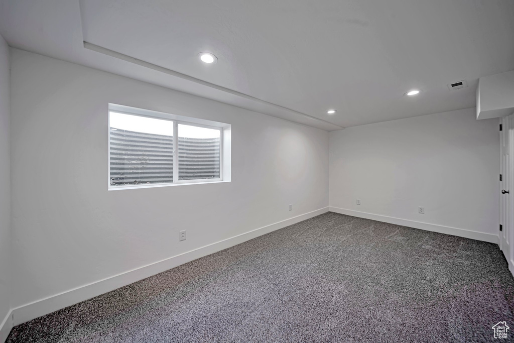 Unfurnished room with baseboards, recessed lighting, and dark colored carpet