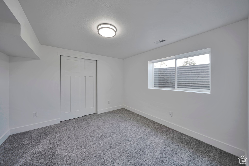 Unfurnished bedroom featuring baseboards, carpet floors, and a closet