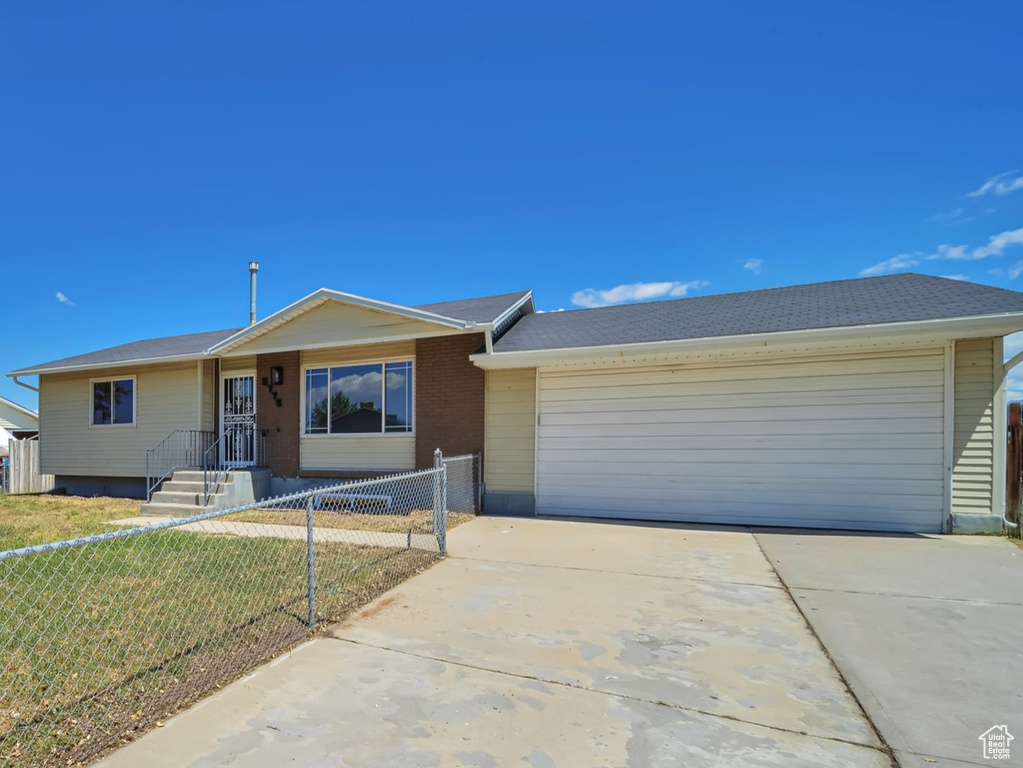 Single story home featuring a garage and driveway