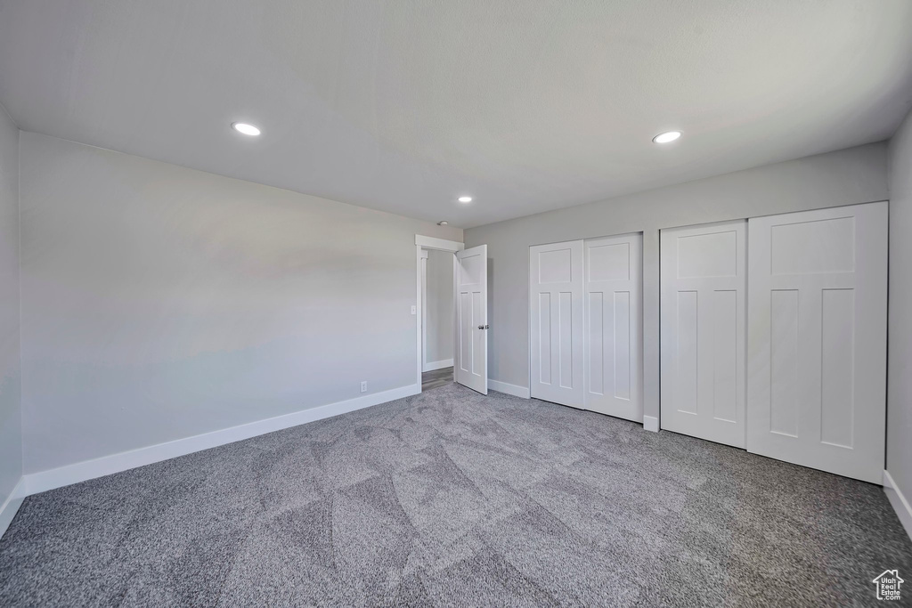 Unfurnished bedroom featuring two closets, carpet floors, baseboards, and recessed lighting
