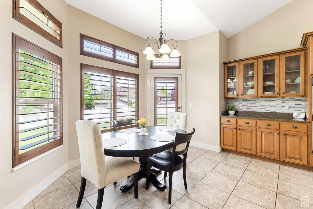Dining room featuring light tile patterned flooring, a chandelier, and baseboards