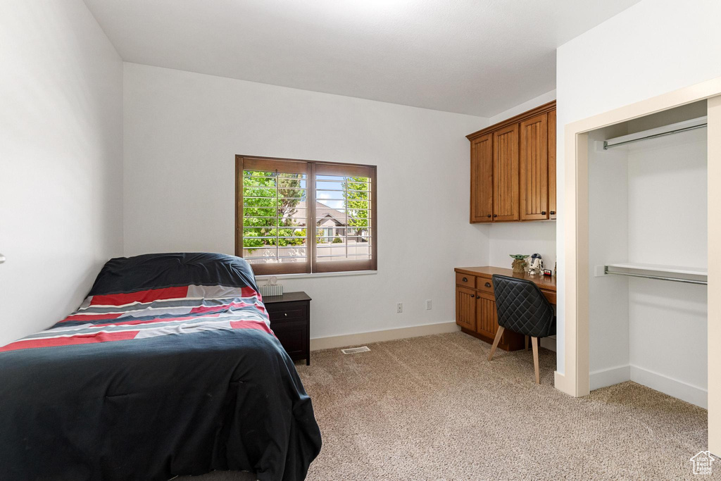 Bedroom featuring light carpet and baseboards