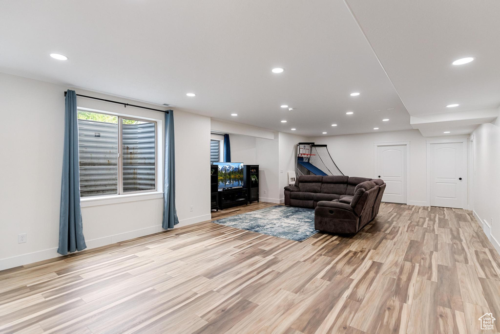 Living room with light wood-type flooring, recessed lighting, and baseboards