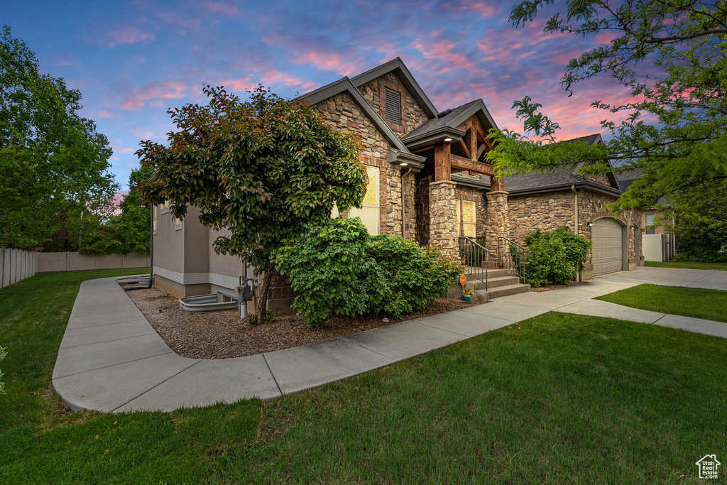 View of front of home featuring stone siding, an attached garage, concrete driveway, and stucco siding
