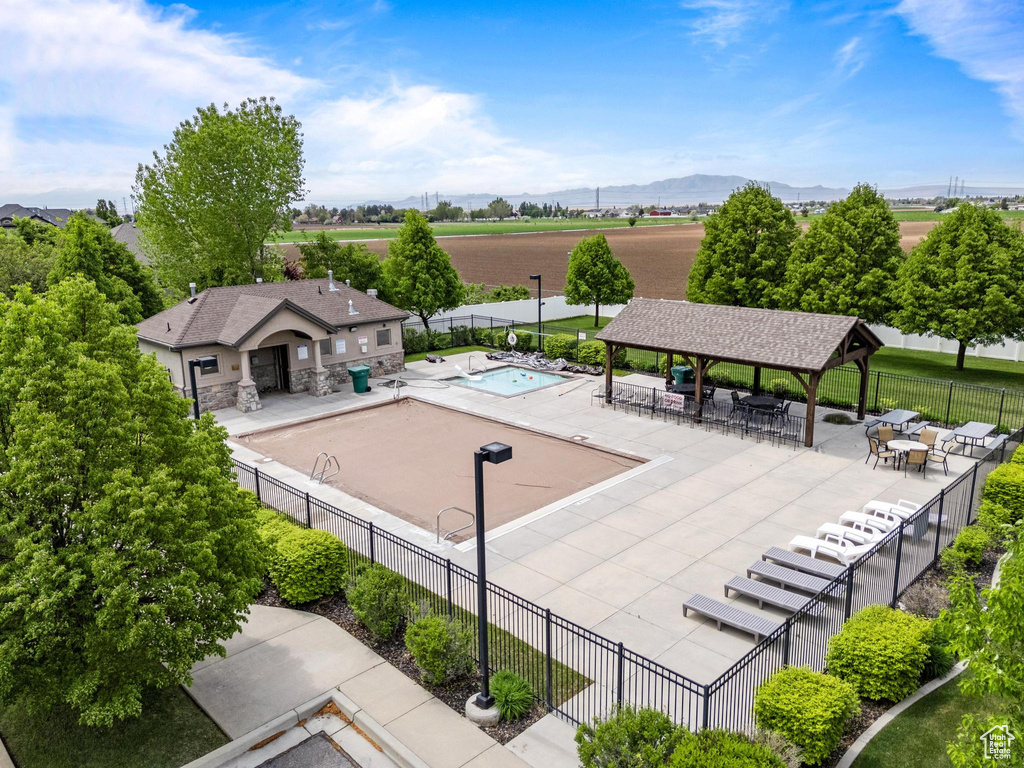 Community pool with a gazebo, fence, a patio area, and a mountain view