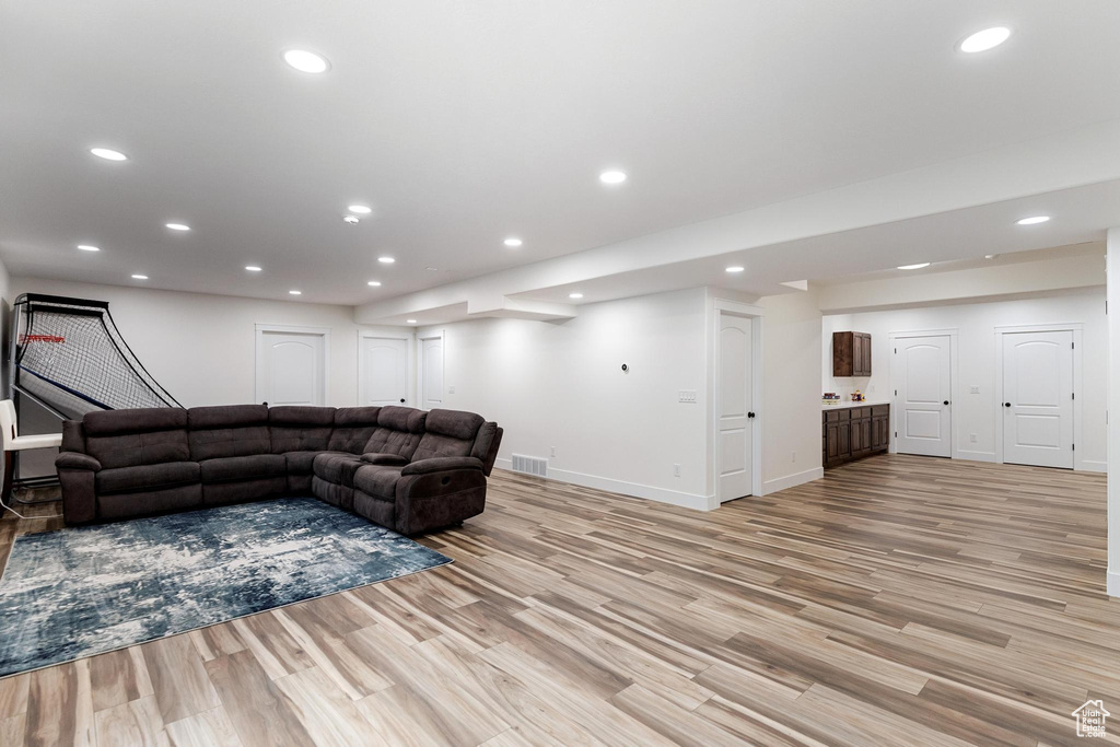 Living area with light wood finished floors, baseboards, and recessed lighting