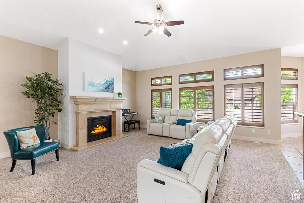 Living area featuring light colored carpet, baseboards, ceiling fan, a fireplace, and recessed lighting
