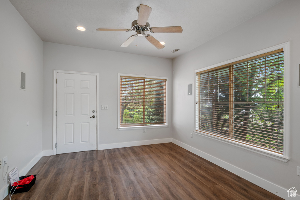 Unfurnished dining area with dark wood-style flooring, baseboards, ceiling fan, and recessed lighting