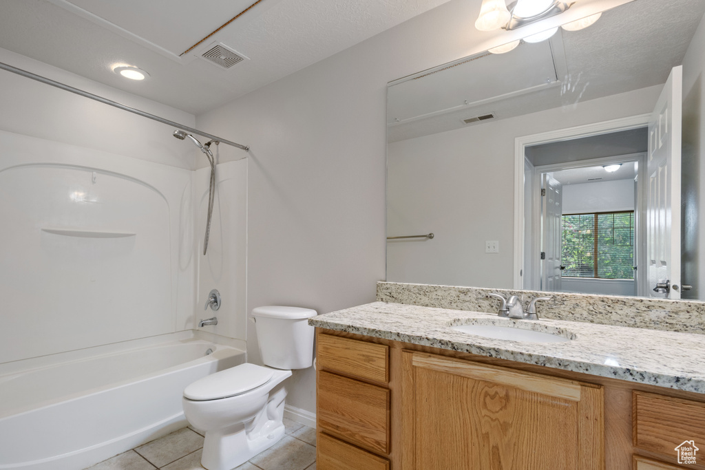 Bathroom with tile patterned flooring, toilet, vanity, baseboards, and bathtub / shower combination