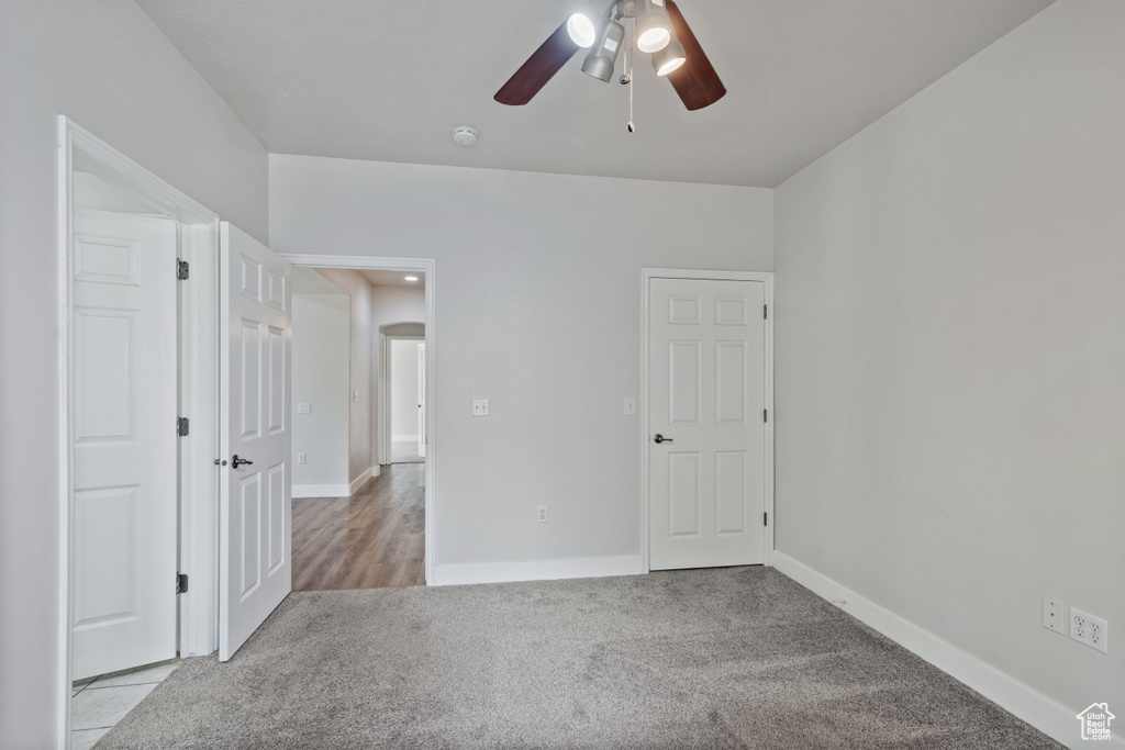 Unfurnished bedroom with carpet, baseboards, and a ceiling fan