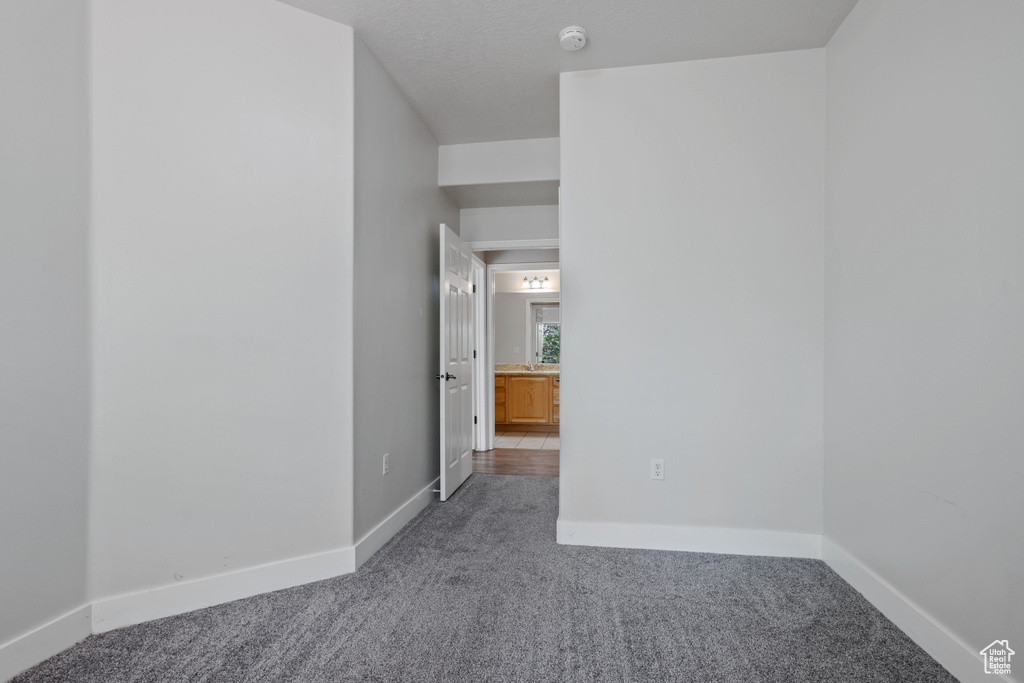 Spare room with carpet floors, a smoke detector, and baseboards
