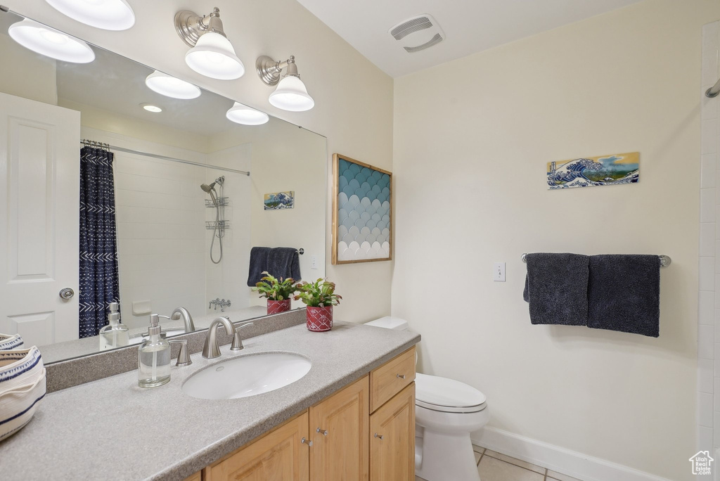 Bathroom with tile patterned flooring, curtained shower, toilet, and vanity