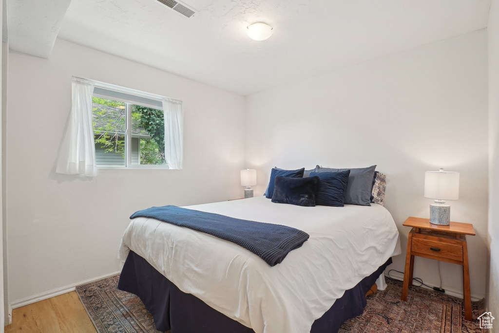 Bedroom with wood finished floors and baseboards