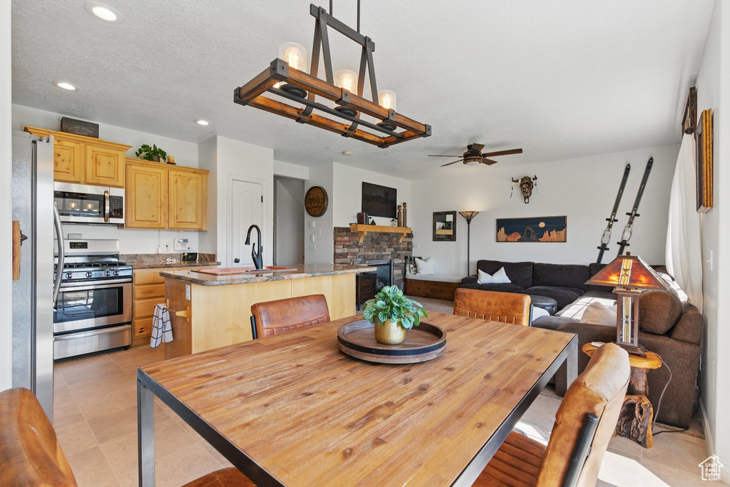 Dining space featuring a ceiling fan, recessed lighting, and a fireplace