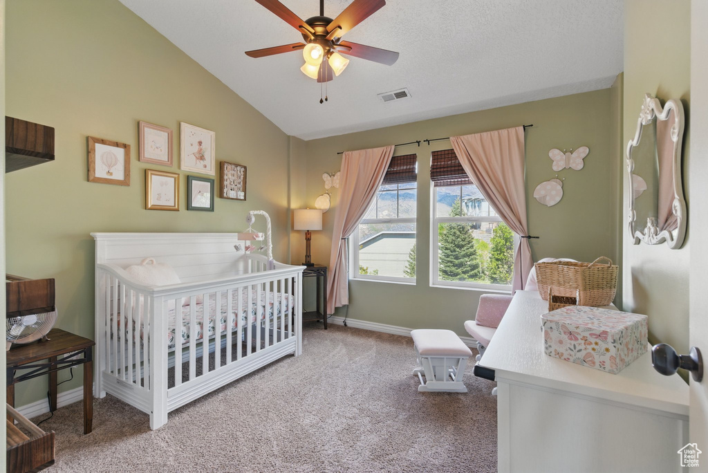 Bedroom featuring a nursery area, carpet, vaulted ceiling, baseboards, and ceiling fan