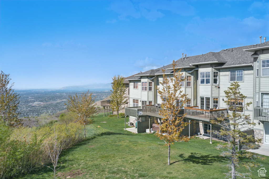 View of grassy yard featuring a deck