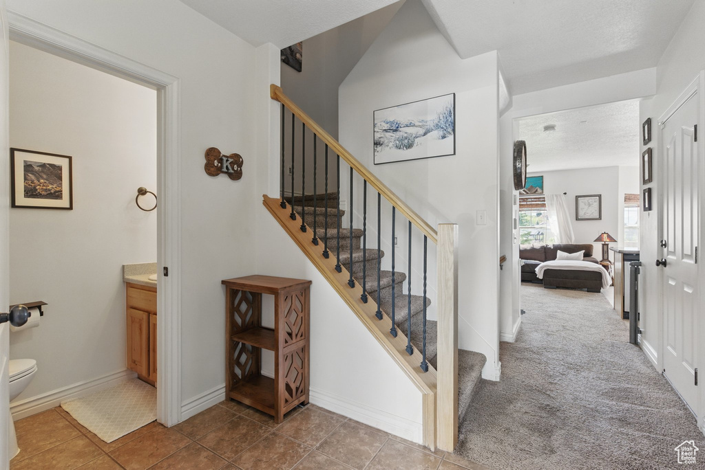 Stairs featuring tile patterned flooring and baseboards