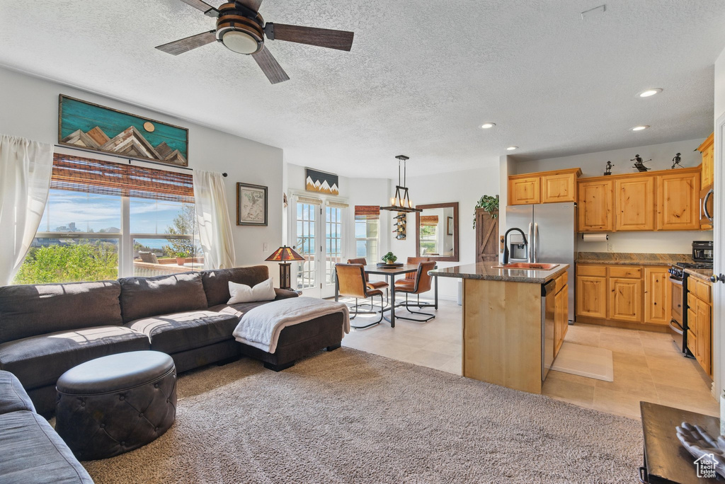 Living area featuring plenty of natural light, recessed lighting, a ceiling fan, a textured ceiling, and a chandelier