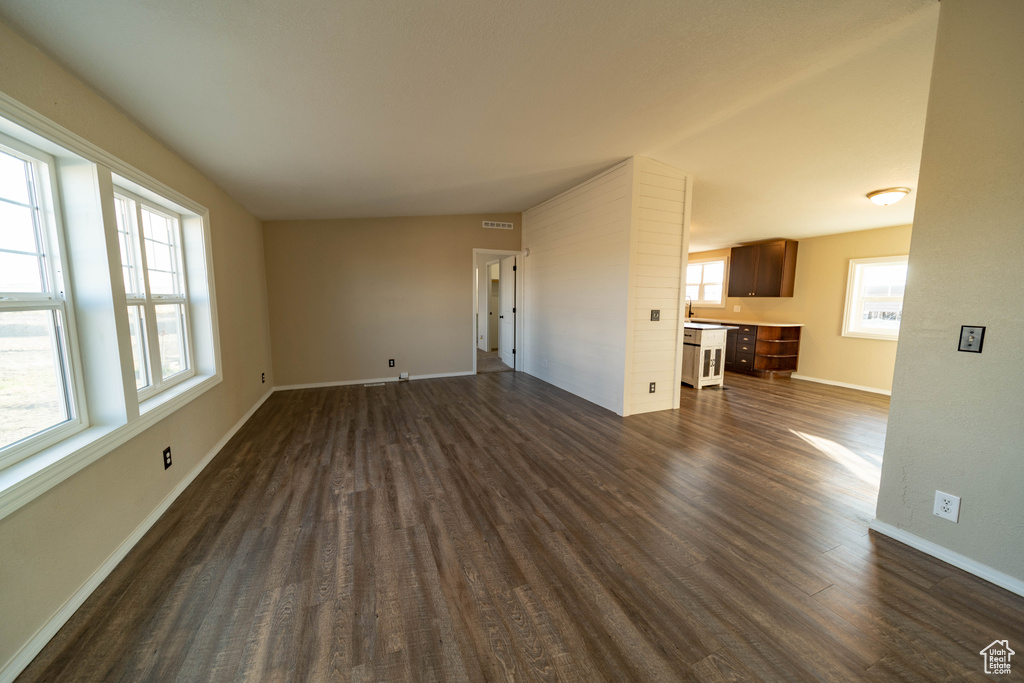 Unfurnished living room with dark wood finished floors and baseboards