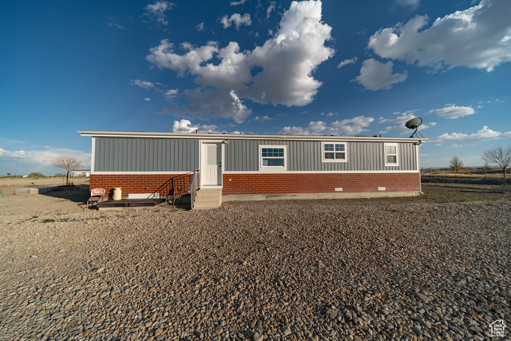 Manufactured / mobile home featuring brick siding, entry steps, and board and batten siding