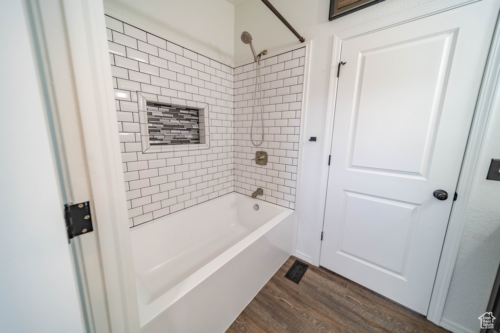Full bathroom with shower / tub combination and wood finished floors