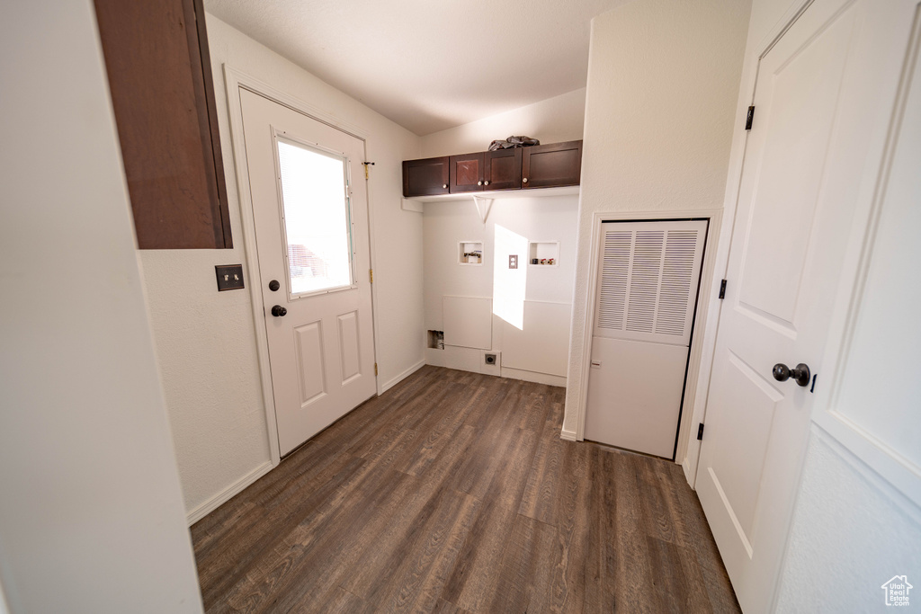 Washroom with a heating unit, dark wood-style flooring, hookup for a washing machine, cabinet space, and hookup for an electric dryer