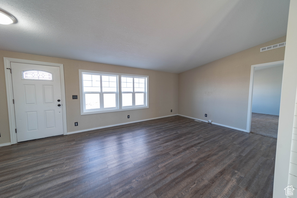 Foyer with dark wood-style floors and baseboards