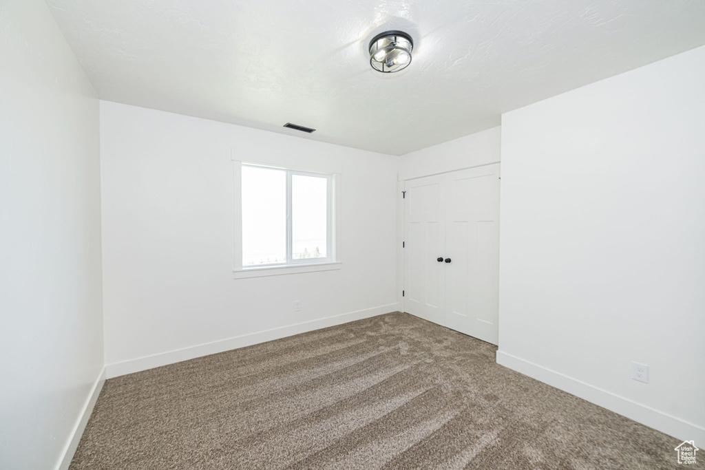 Carpeted spare room with baseboards