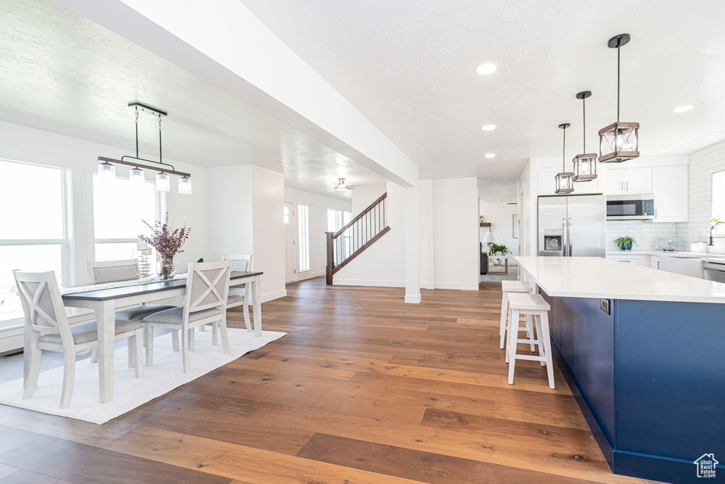 Kitchen featuring recessed lighting, light countertops, appliances with stainless steel finishes, and hardwood / wood-style floors