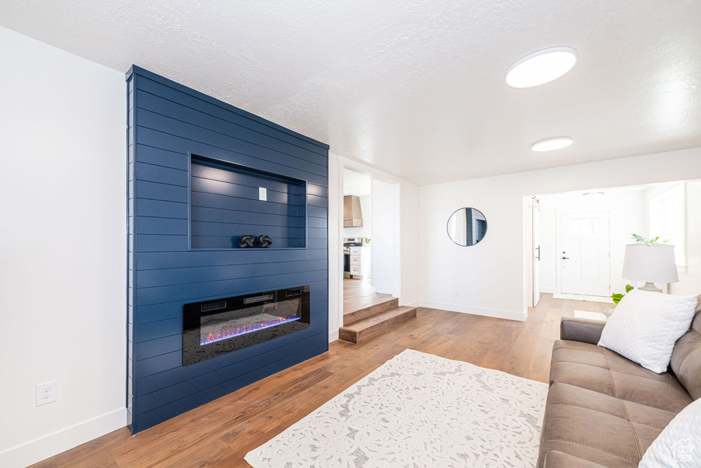 Living room featuring baseboards, wood finished floors, and a fireplace