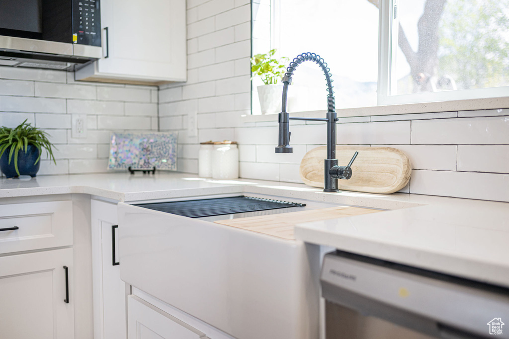 Details featuring decorative backsplash, stainless steel microwave, and dishwasher