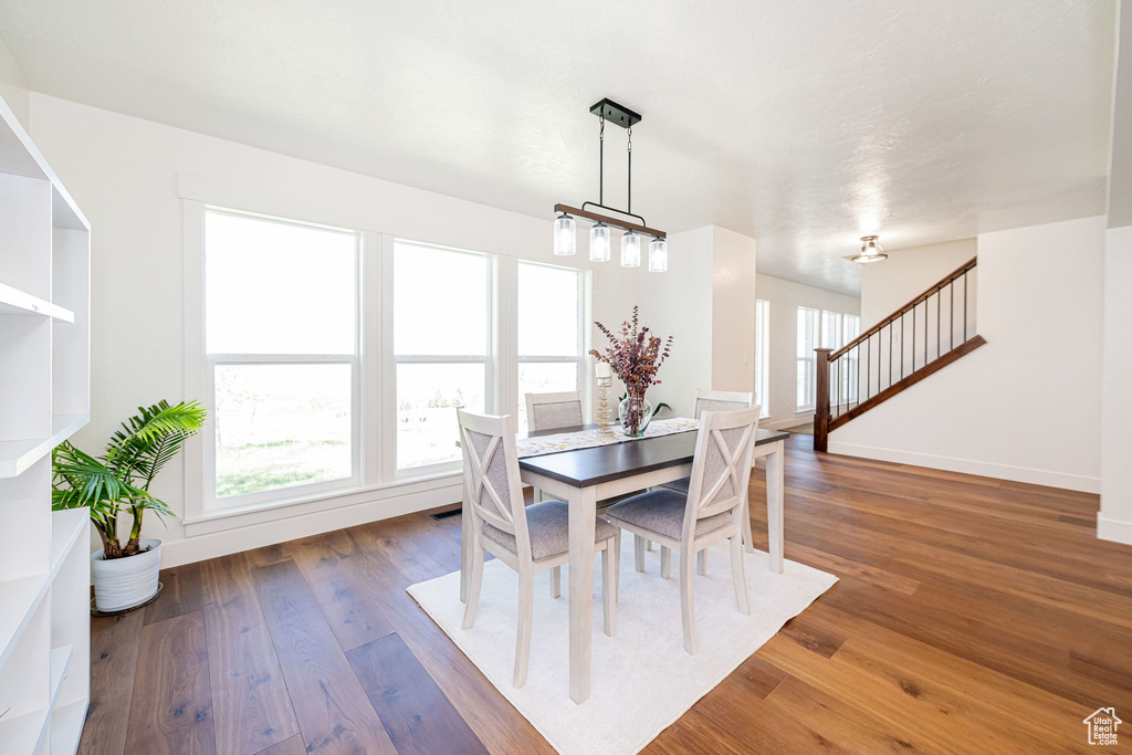 Dining room featuring baseboards, stairs, and wood finished floors