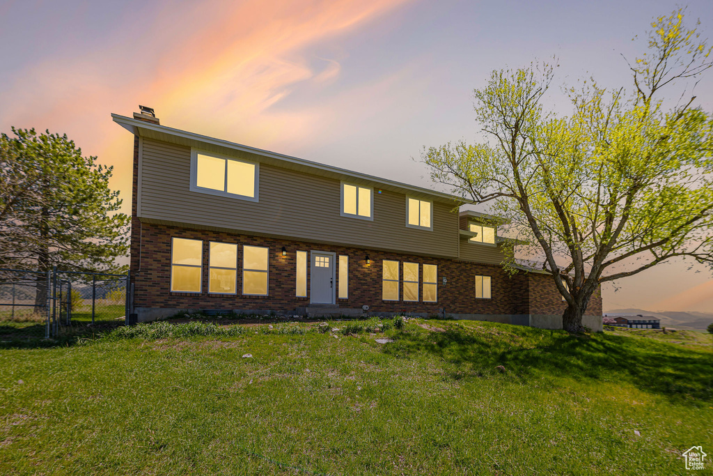 Back of house featuring a chimney and brick siding