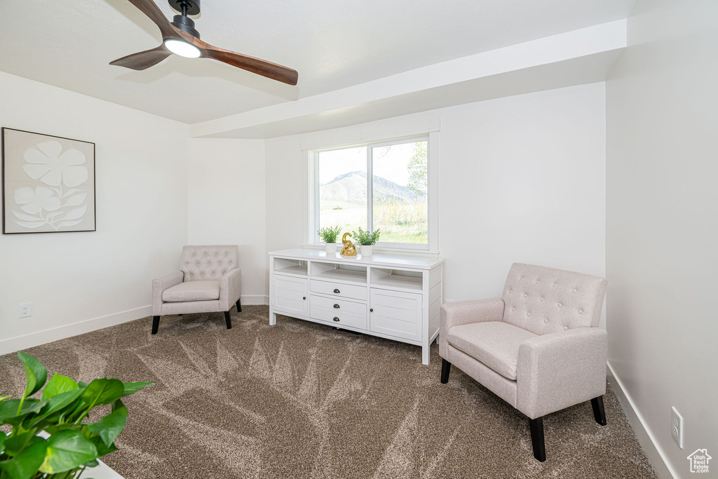 Living area with ceiling fan, baseboards, and carpet