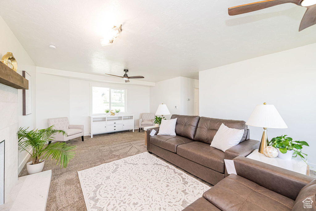 Carpeted living area with ceiling fan