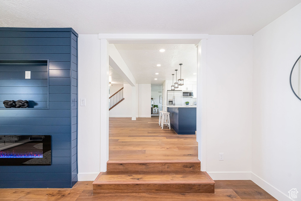 Stairway with baseboards, recessed lighting, and wood finished floors