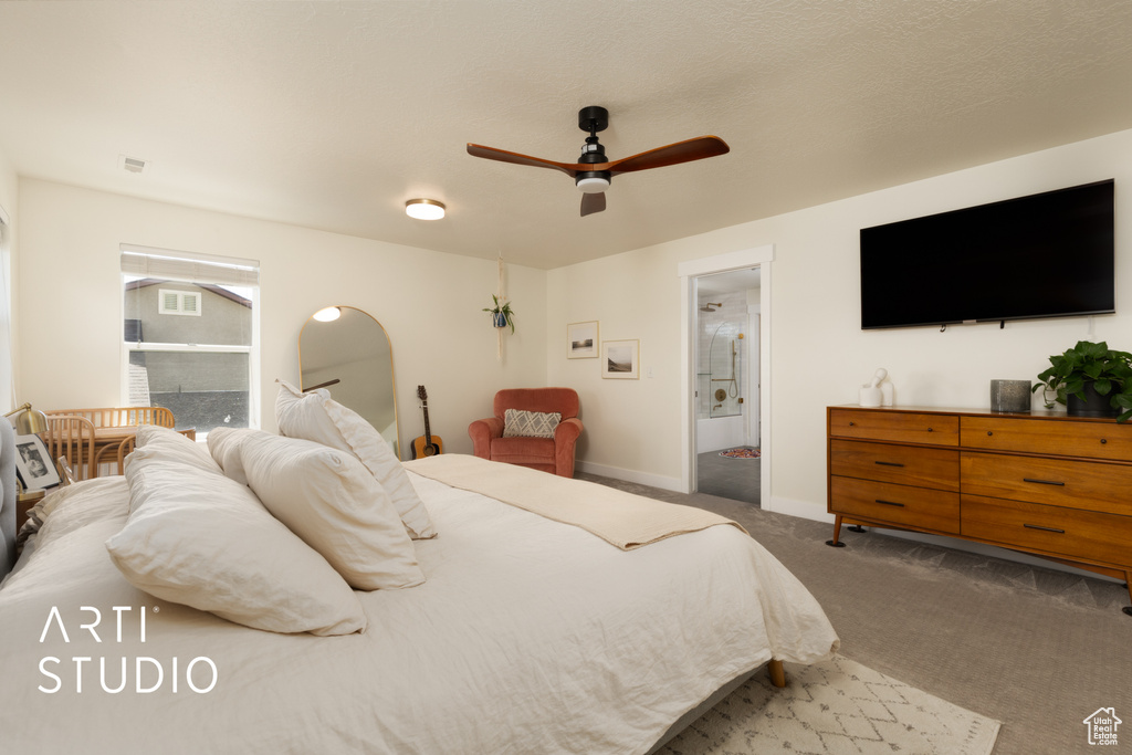 Carpeted bedroom featuring connected bathroom, baseboards, and a ceiling fan