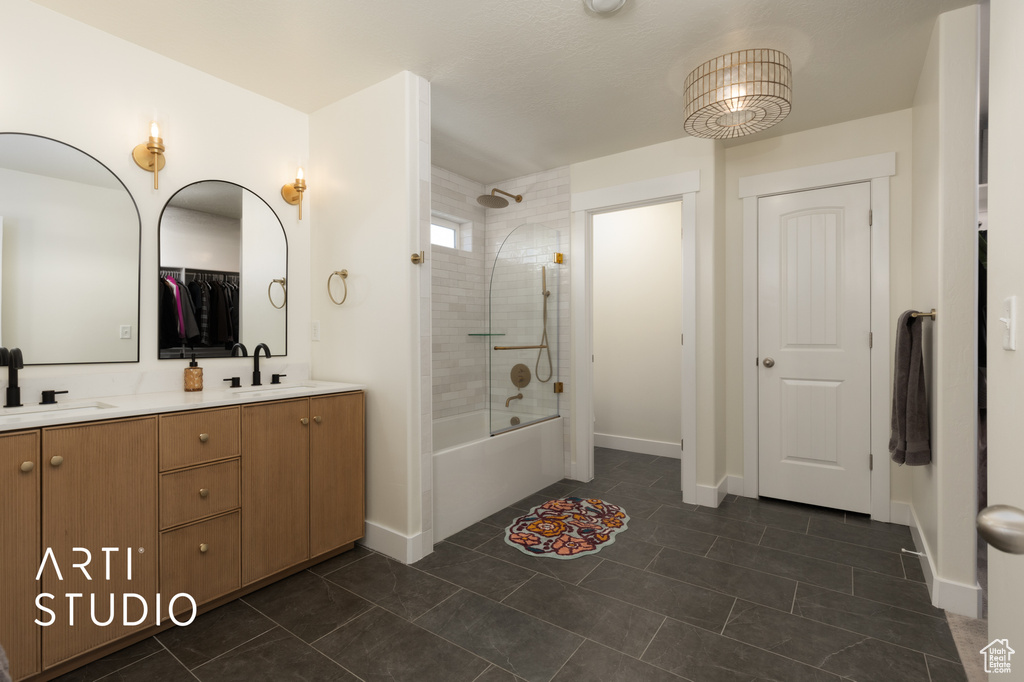 Bathroom with shower / washtub combination, baseboards, double vanity, and tile patterned floors