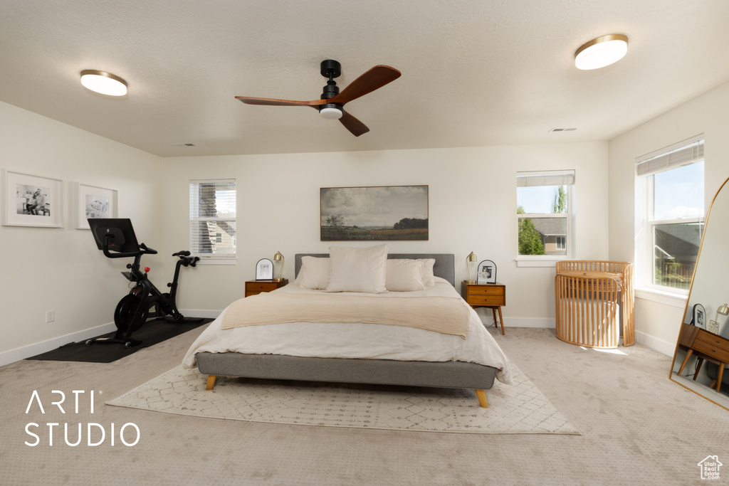 Bedroom with carpet, multiple windows, baseboards, and ceiling fan