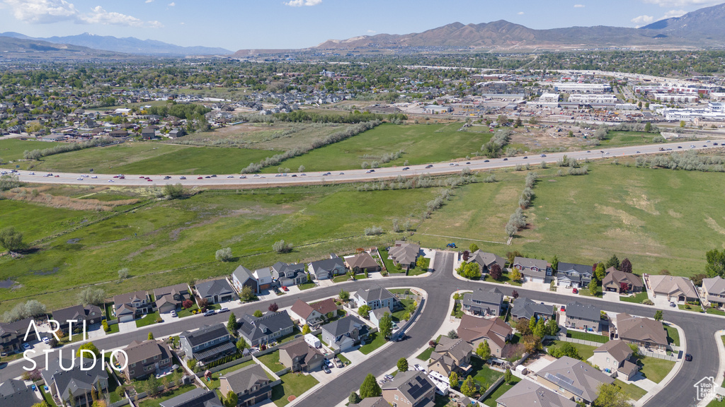 Aerial view of property and surrounding area with a mountain backdrop and nearby suburban area