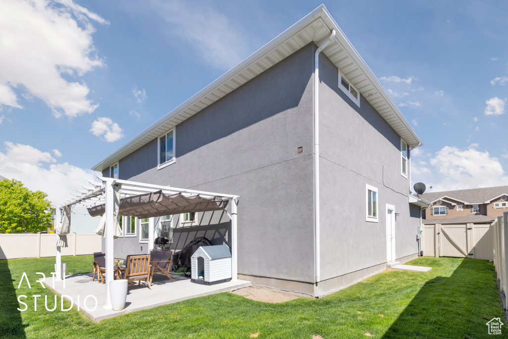 Back of house with a pergola, a gate, a patio area, and stucco siding
