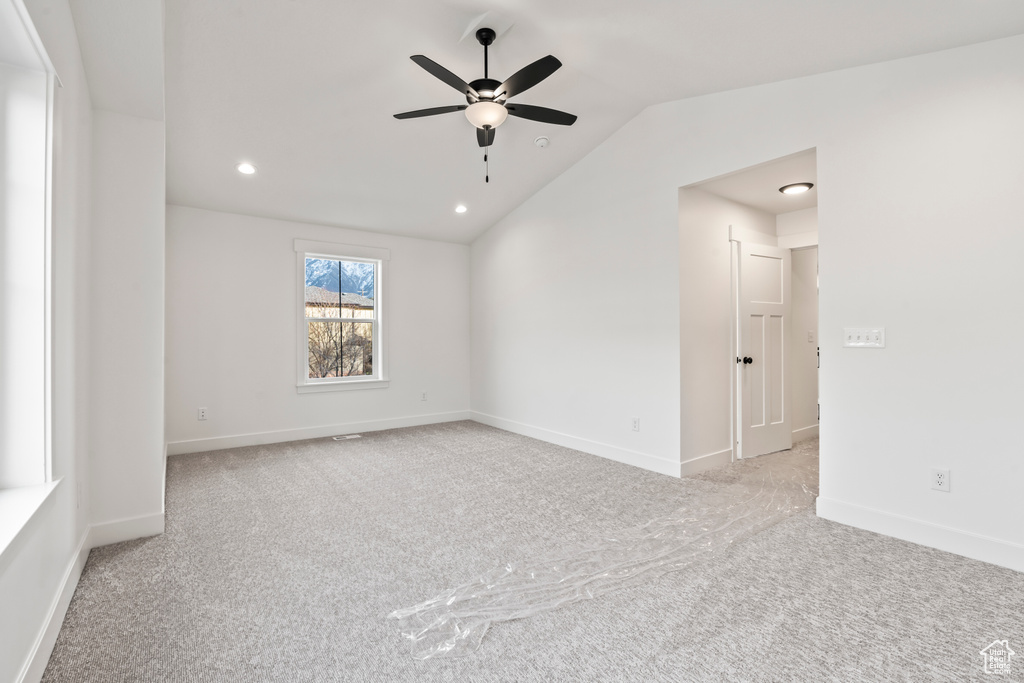 Carpeted spare room featuring a ceiling fan, vaulted ceiling, recessed lighting, and baseboards