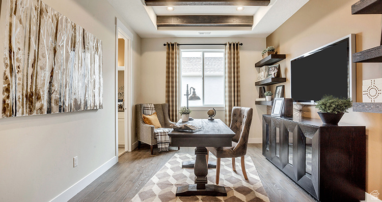Dining space featuring a tray ceiling, wood finished floors, and baseboards