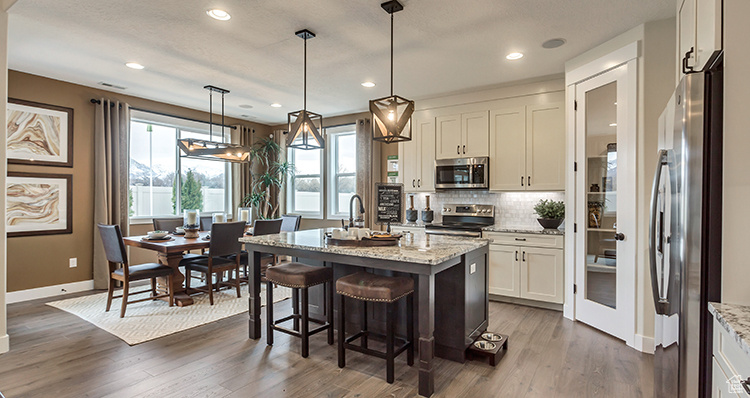 Kitchen with appliances with stainless steel finishes, baseboards, backsplash, white cabinetry, and dark wood finished floors