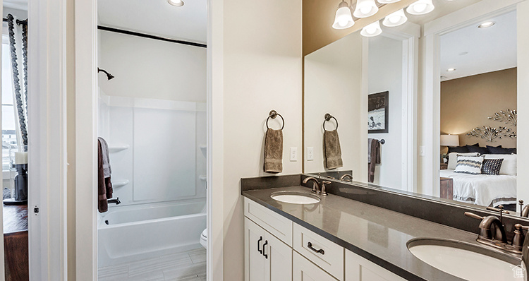 Ensuite bathroom featuring double vanity, toilet,  shower combination, and recessed lighting