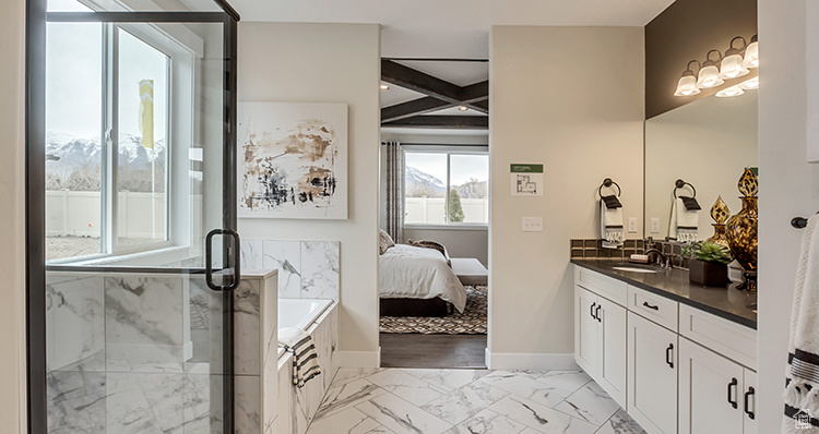 Full bathroom featuring a stall shower, marble look tile flooring, vanity, ensuite bathroom, and a tub to relax in