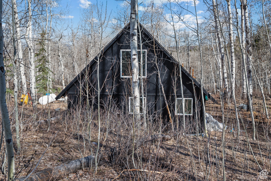 View of outbuilding featuring a view of trees
