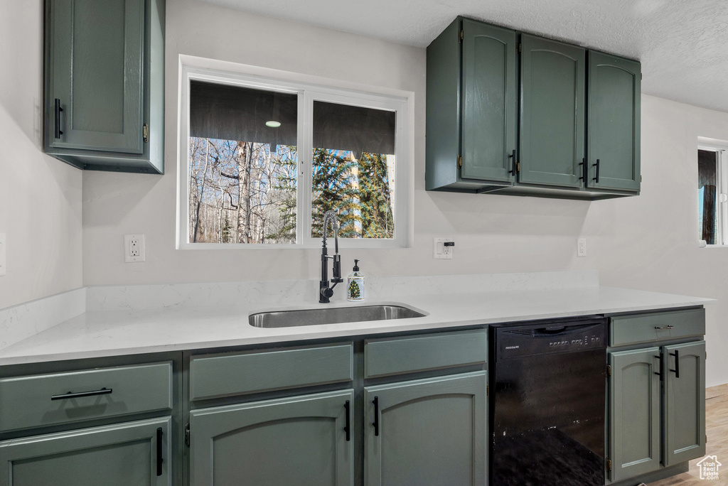 Bar featuring dishwasher, a sink, wood finished floors, and a textured ceiling